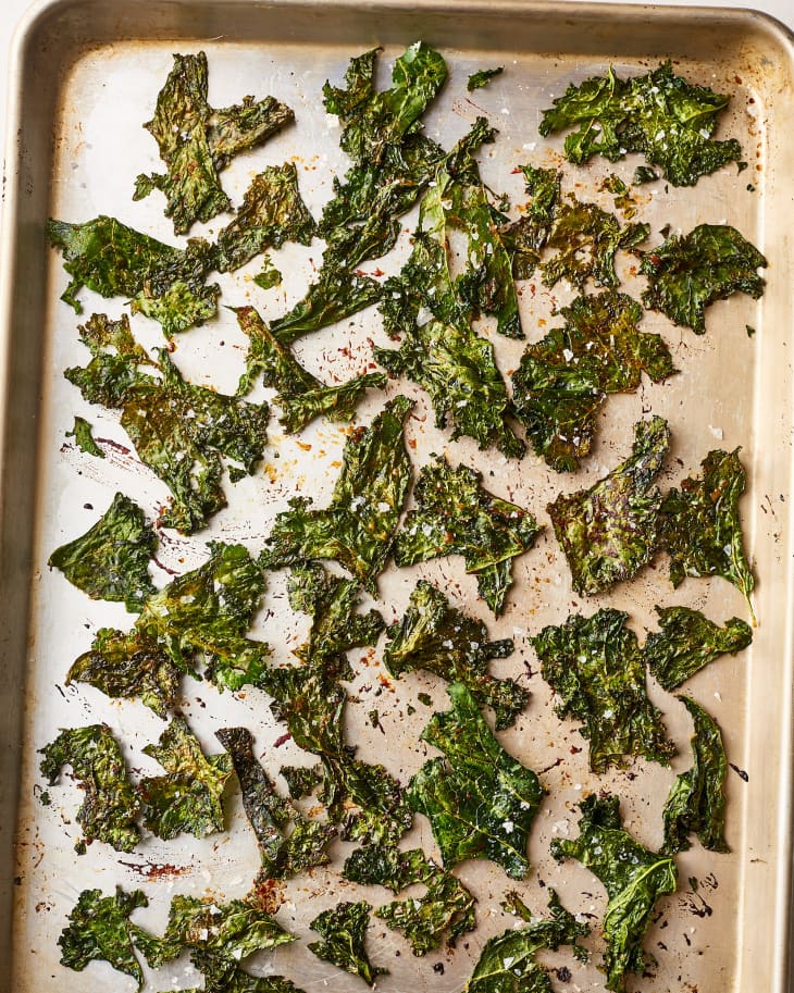 A top shot of oven-baked kale chips in a sheet pan