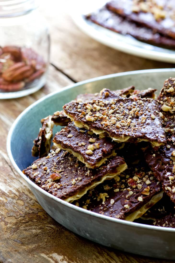 Pieces of chocolate caramel matzo brittle stacked together in a wide bowl