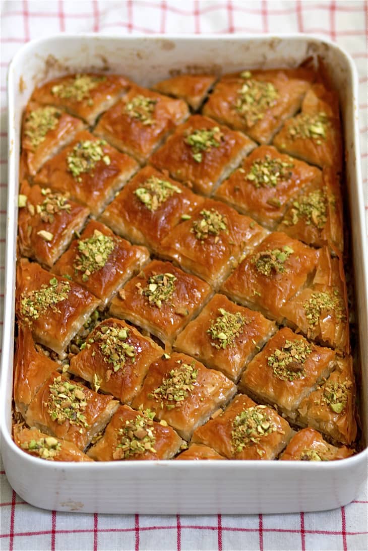 Baklava, garnished with chopped pistachios, equally divided and sliced in a baking pan