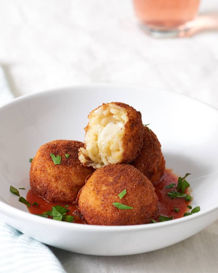 Creamy rice and gooey cheese fill the risotto ball in a bowl