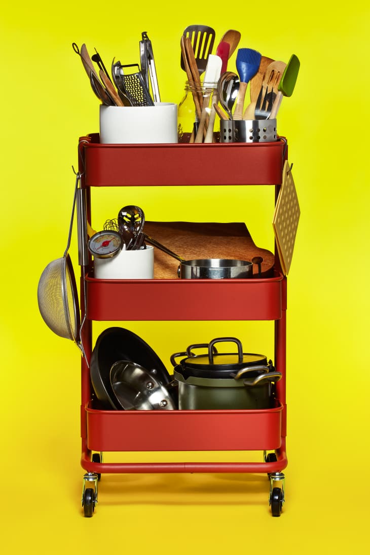 A red rolling cart stores most-often used kitchen essentials, including pots, pans, and daily kitchen tools