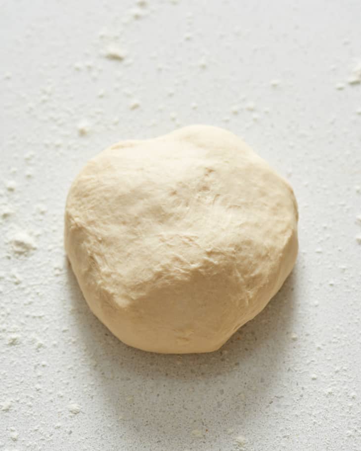 Ball of dough on a floured surface, ready for baking or cooking.