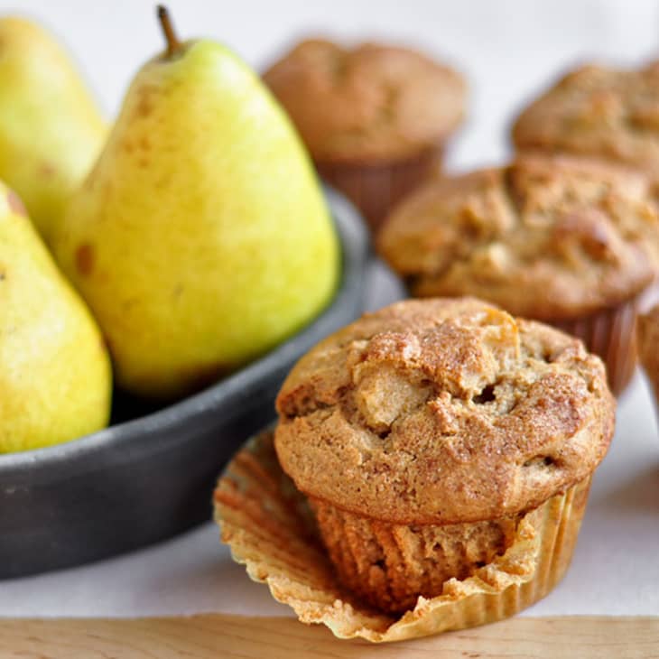 Baked spiced pear muffins are pictured with fruit pear