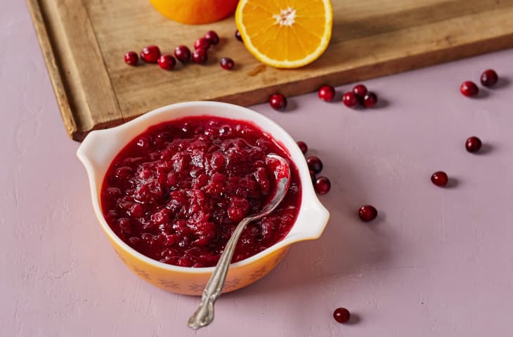 Rich, chunky cranberry sauce in a bowl with a spoon in it