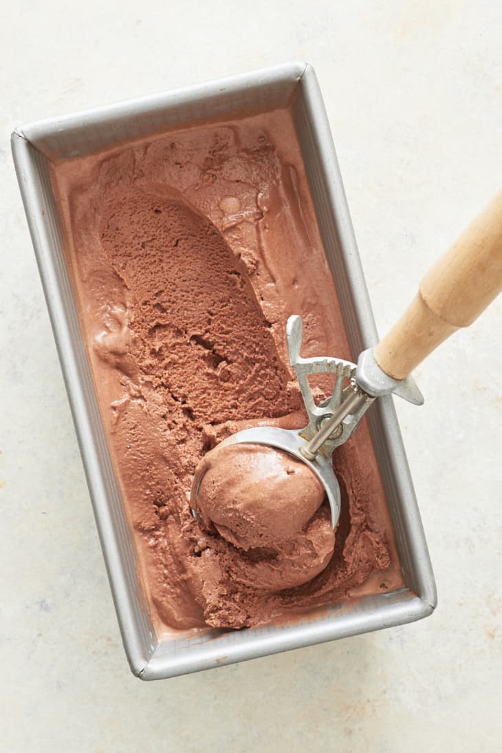 Chocolate ice cream is scraped onto an ice cream scoop