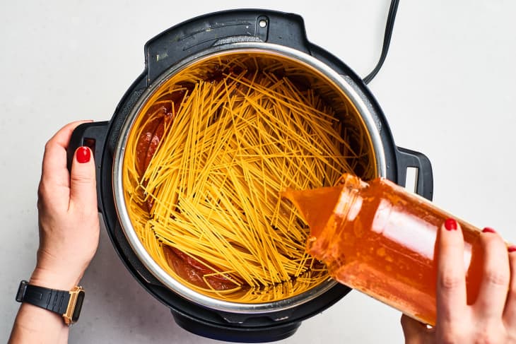 Adding water to uncooked spaghetti, sauce, and ground beef in an Instant Pot
