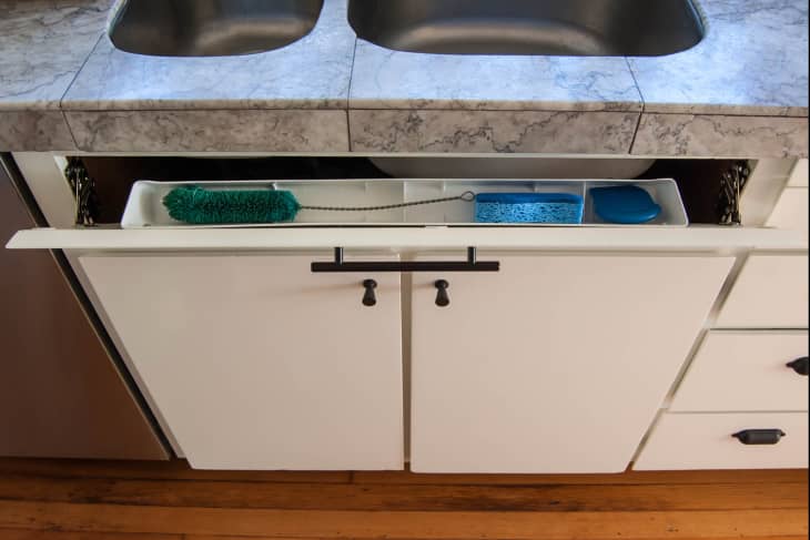 A tip out tray kit is installed behind a vacant panel between the countertop and under-sink cabinet