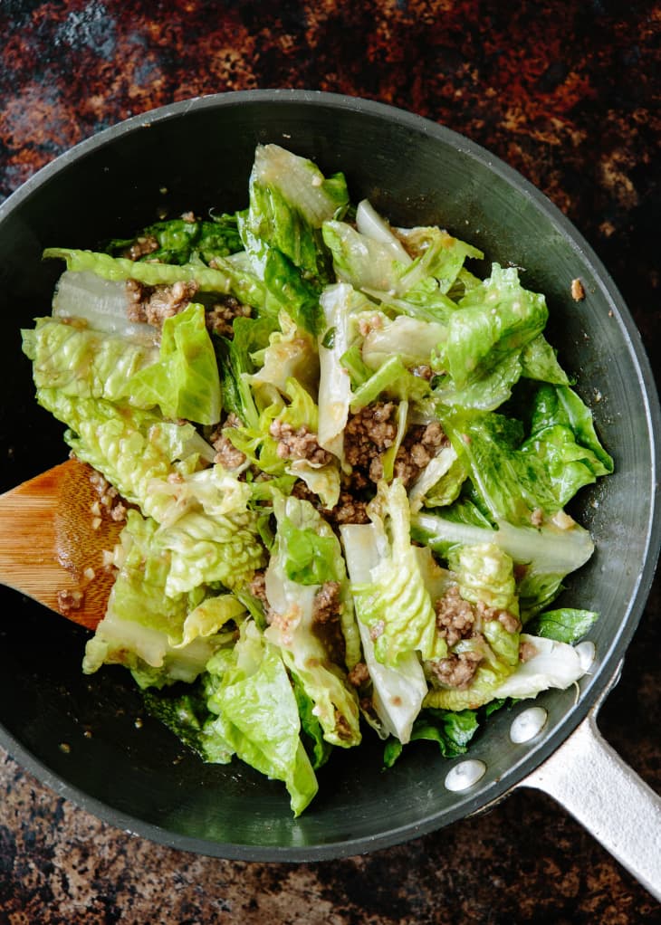 Lettuce salad with hot beef dressing in a pan