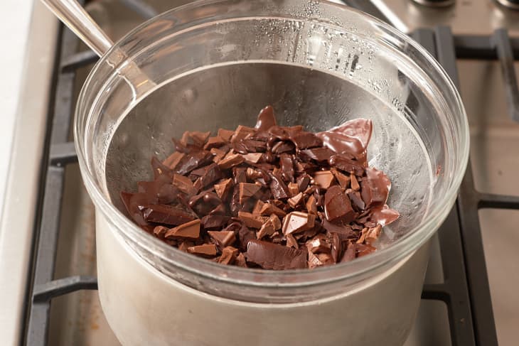 A mix of dark and milk chocolate pieces in a medium bowl over a pot