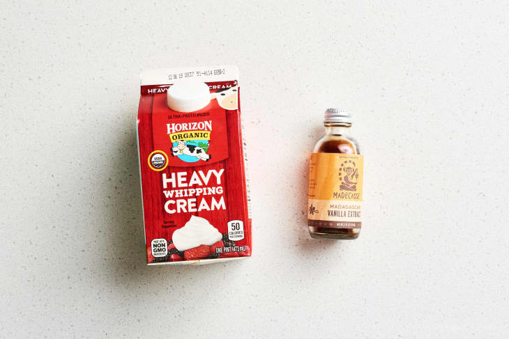 A carton of heavy whipping cream and a bottle of vanilla
