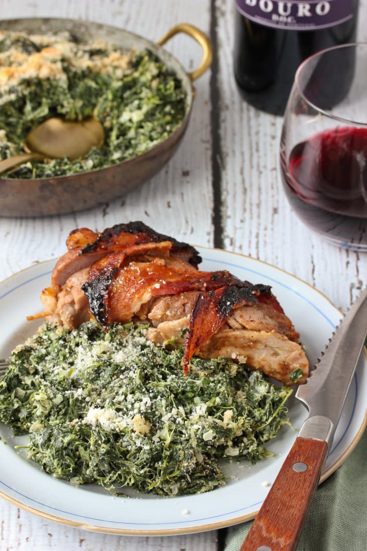 Creamy spinach bake served with chicken thighs on a plate with knife on the side