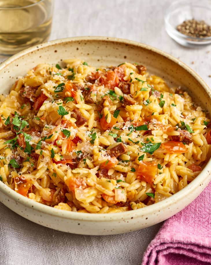Cheesy orzo with tomatoes and smoky Spanish chorizo in a plate
