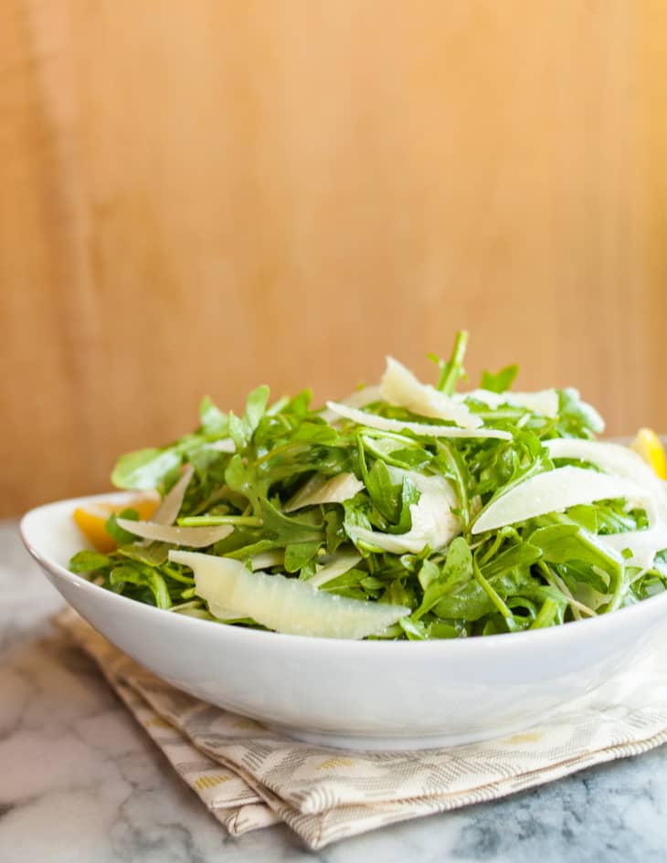 Arugula and fennel salad with Pecorino cheese, drizzled with lemon vinaigrette, in a bowl