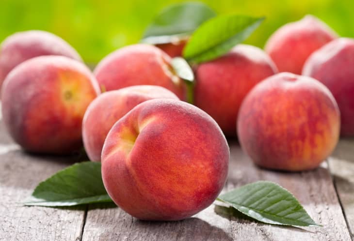 whole peaches on wooden planks