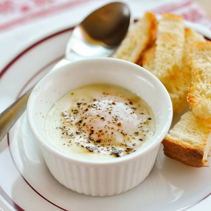 Eggs en Cocotte in a ramekin, served with slices of toast