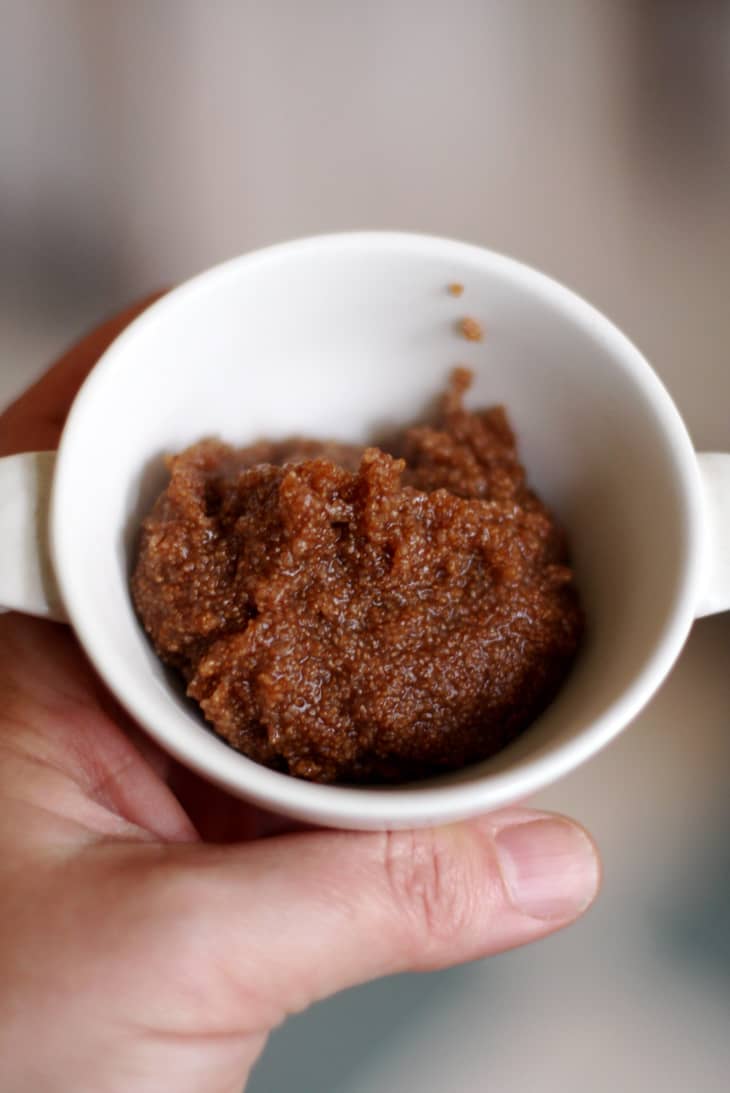 Someone holds a cup filled with whole-grain teff porridge