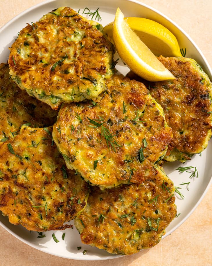zucchini pancakes on plate with lemon wedges