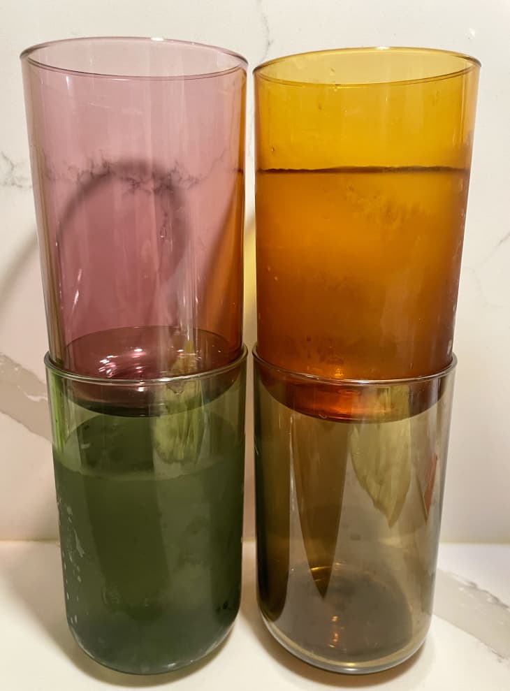 4 Tossware glasses in different colors on a countertop