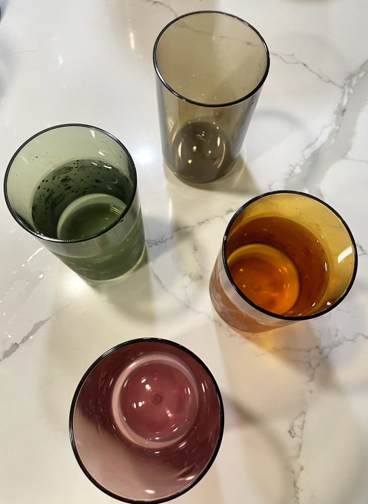 4 Tossware glasses in different colors on a countertop