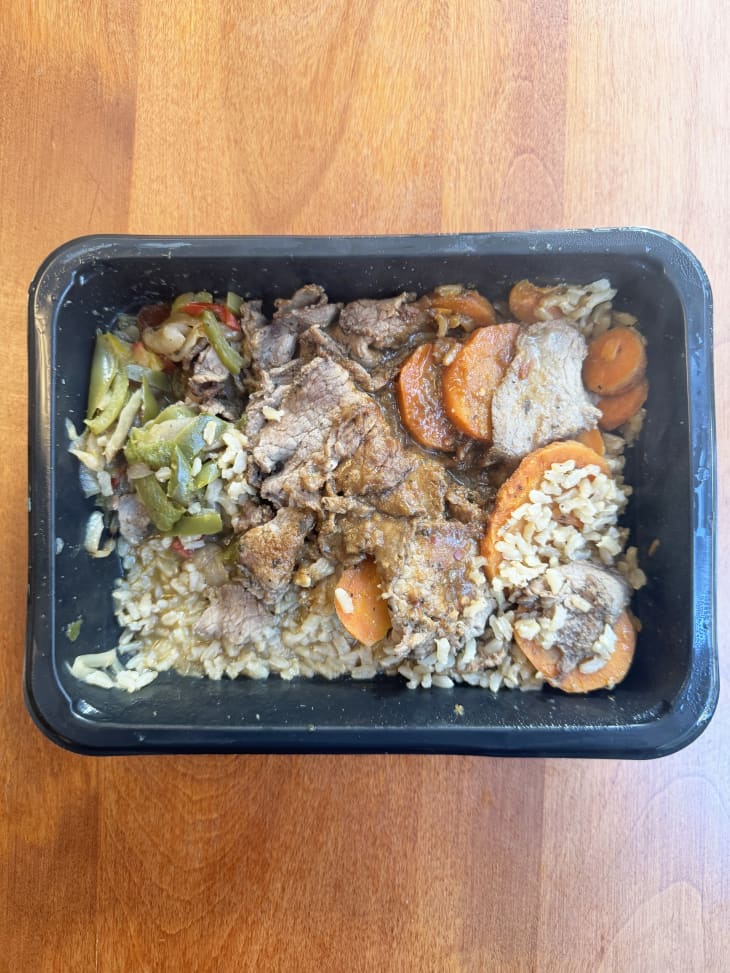 rice, chicken, and vegetables in black heating container