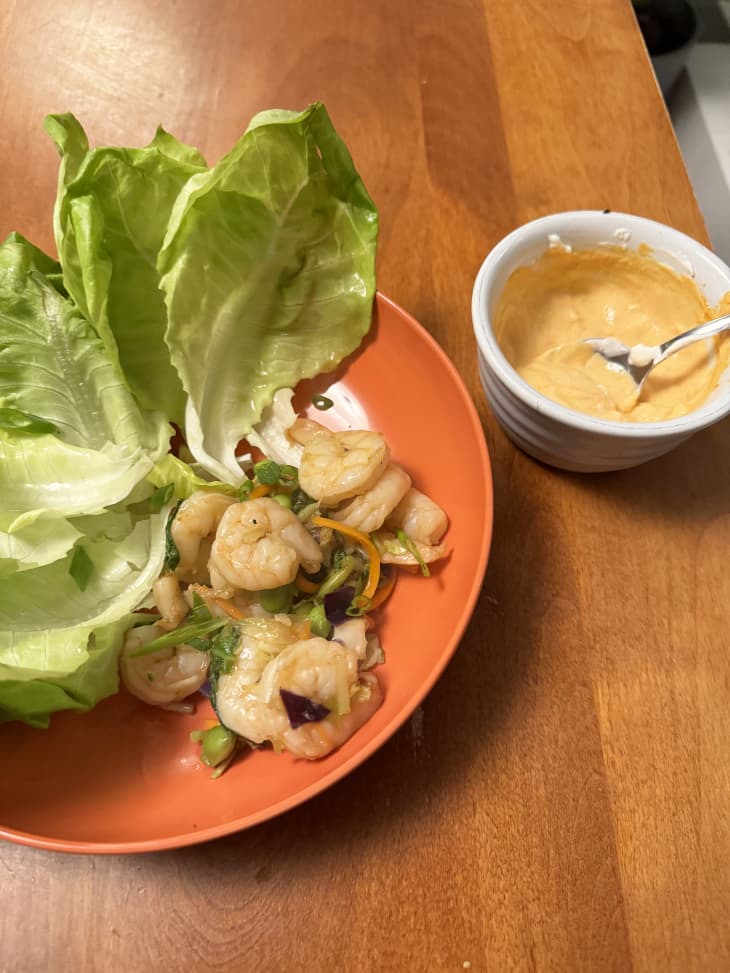 fried shrimp in lettuce cups with creamy sauce on orange plate