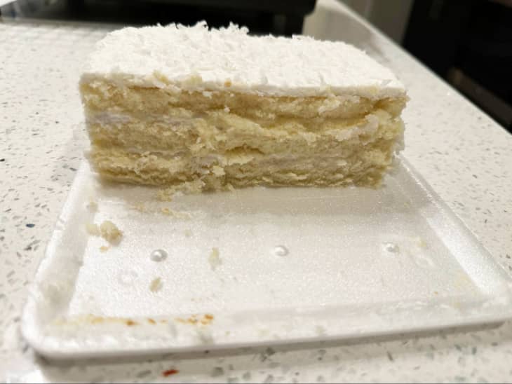 white coconut layer cake on styrofoam plate