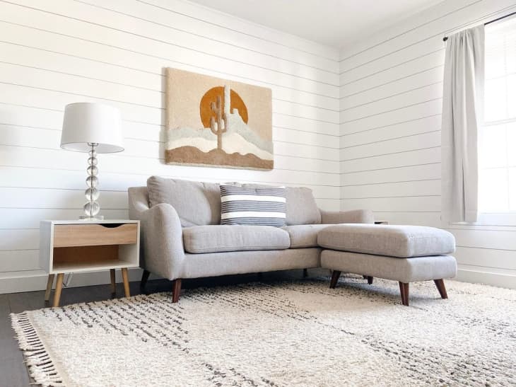 a minimalist living room features white shiplap with desert wall decor