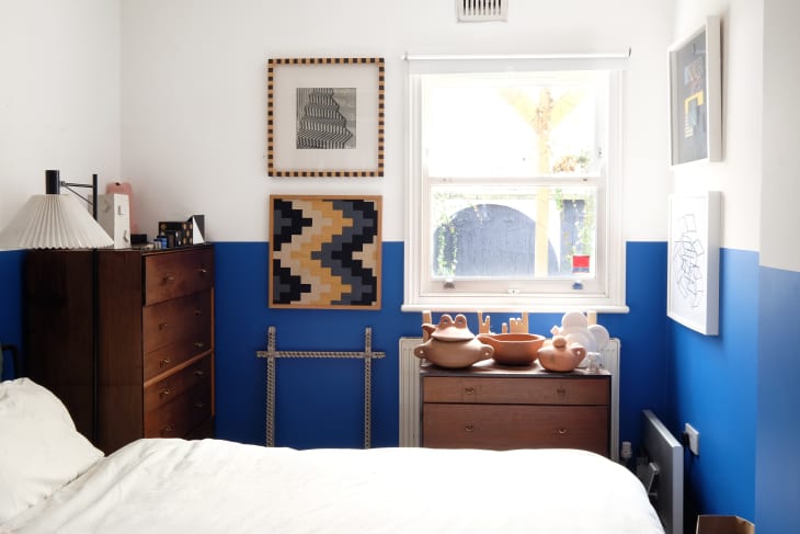 A bedroom with a white and blue wall