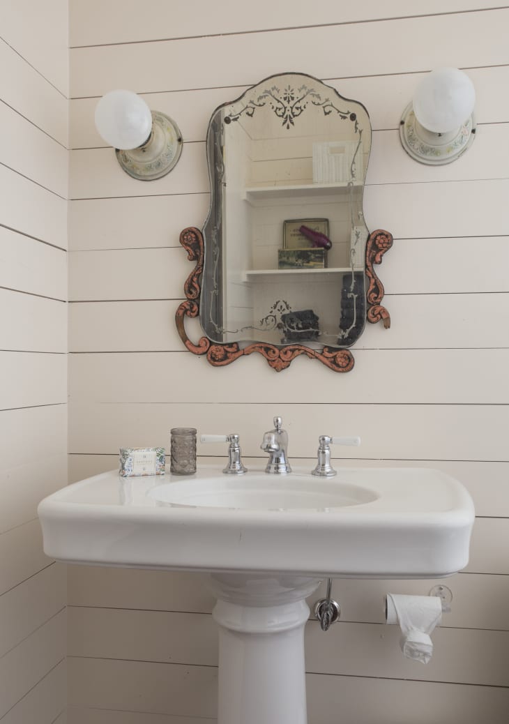 Powder room with white shiplap and vintage mirror