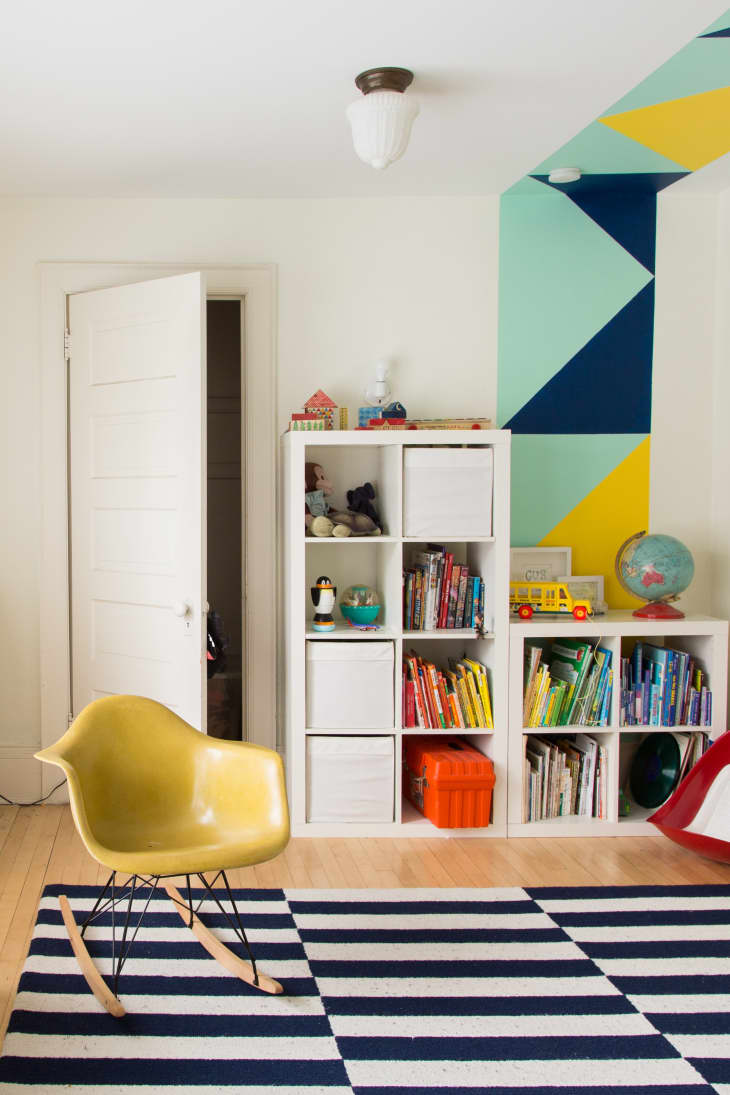 a kids' playroom with children's books organized by color