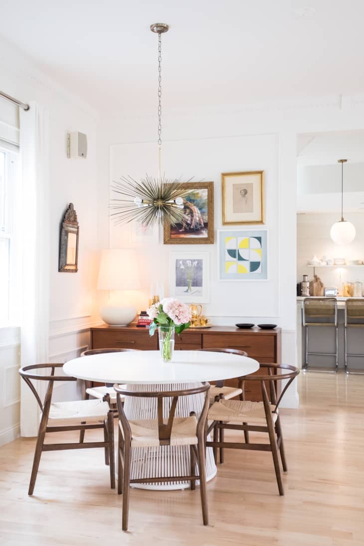 Wooden dining chairs at a white table.