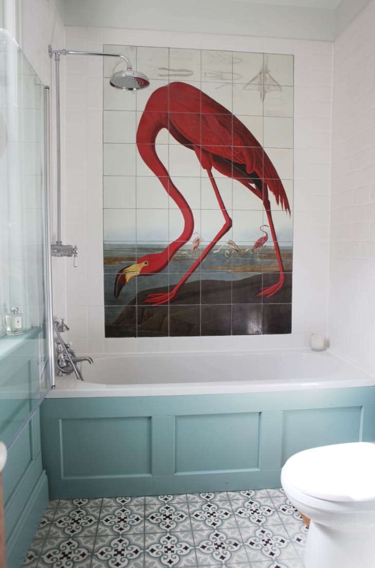 A flamingo tile mural on a bathroom wall.