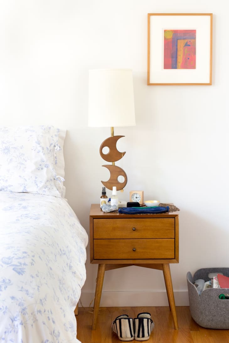 A midcentury night stand with a midcentury light fixture.