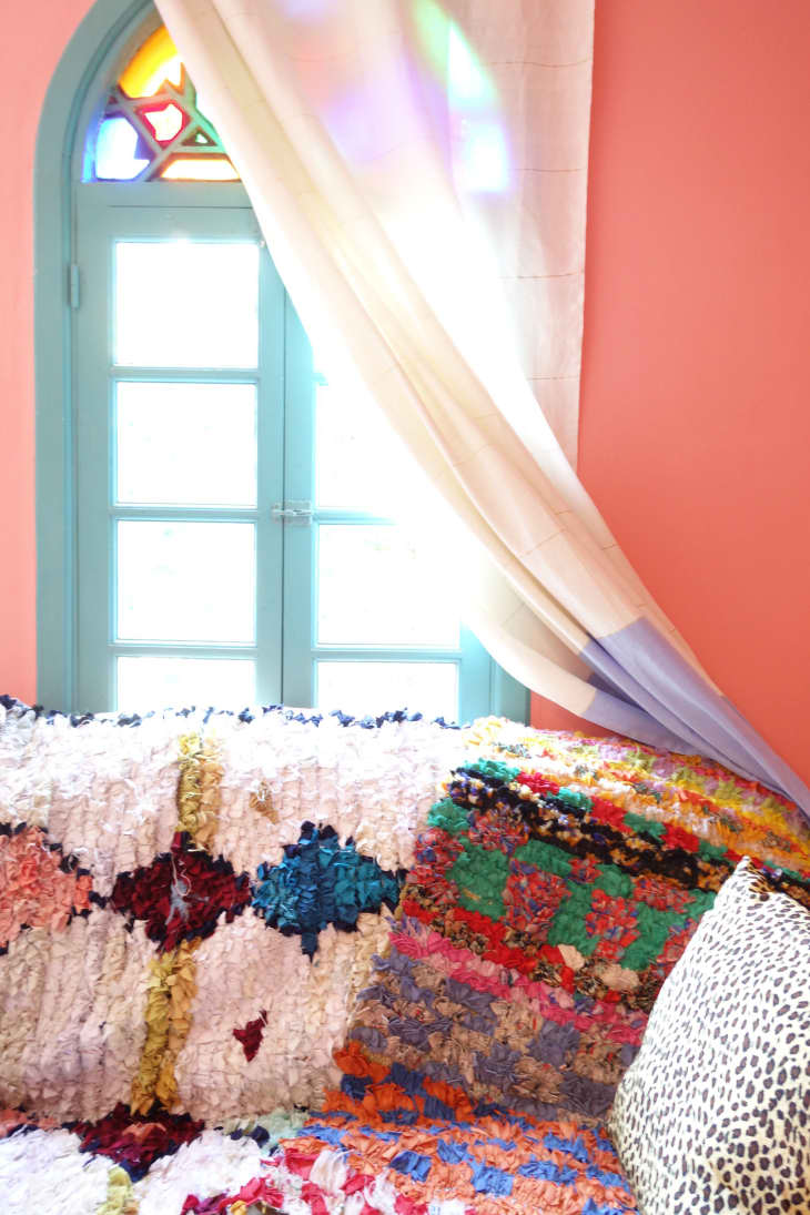 Colorful pillows and blankets in a pink room