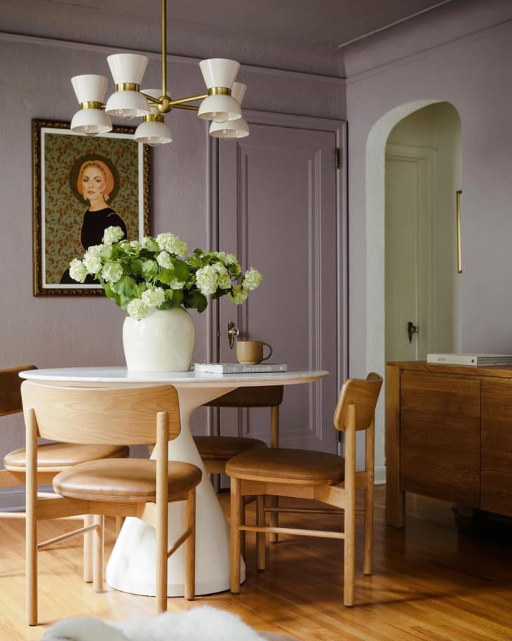 a dining room is decorated with light purple paint and light wood furniture