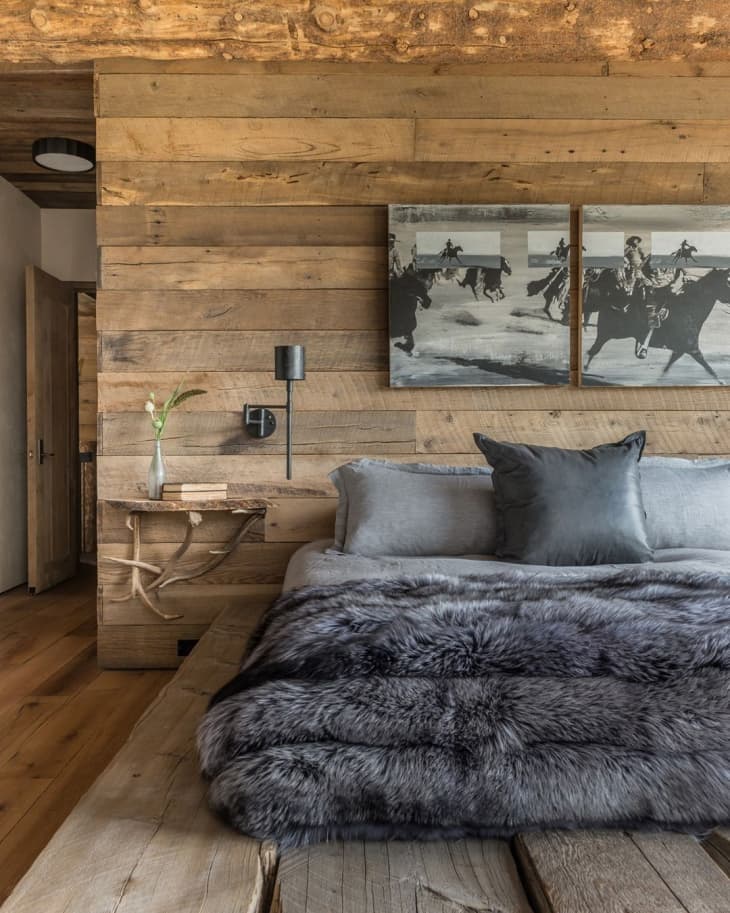 a rustic bedroom with gray faux fur bedding
