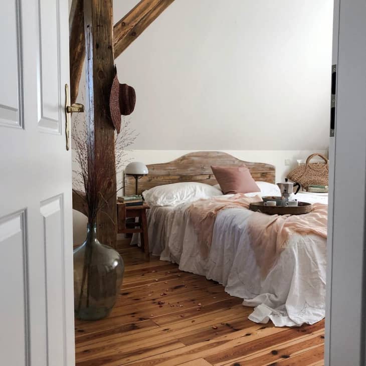 rustic bedroom with pink throw and pillow on the bed