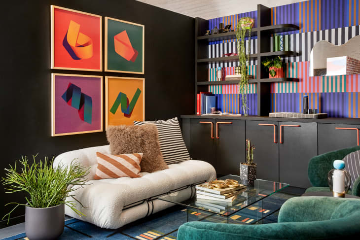 Colorful room in with a mix of deco and memphis group style. Patterned wallpaper, colorful abstract art prints on wall. Geometric, bright decor accents