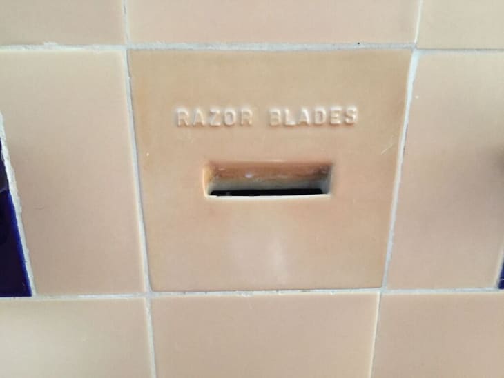 Razor blade disposal slot in wall of bathroom of historic home.