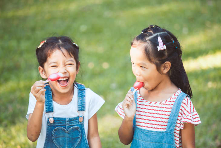 Happy Girls Eating Popsicles At Park