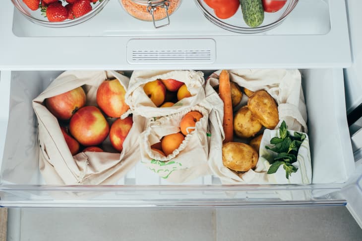 Zero waste concept. Fresh vegetables and fruits in eco cotton bags (tote bag) in a refrigerator from market. Shopping concept