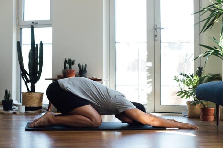 Young man doing yoga exercise at home