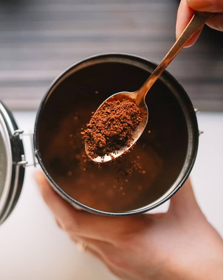 Cropped Hands Of Woman Scooping Ground Coffee From Reusable Container