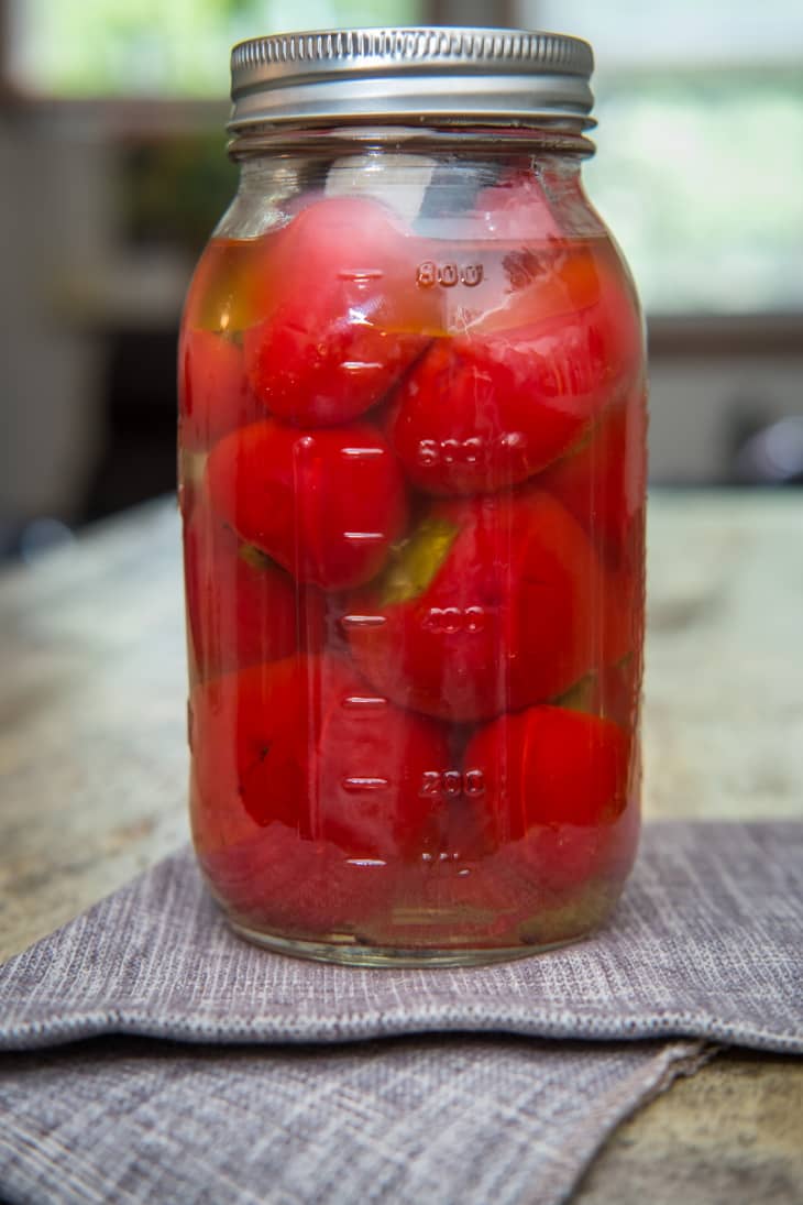 glass mason jar full of cherry peppers, linen napkin
