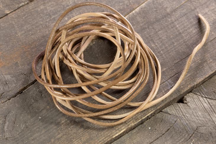 a bunch of leather string sitting on a wood surface