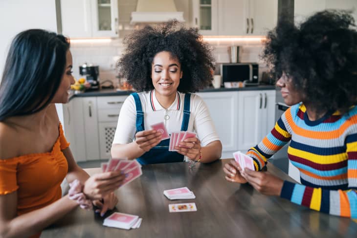 Three girls at home playing cards