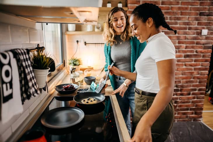 Girl friends couple cooking in the kitchen together