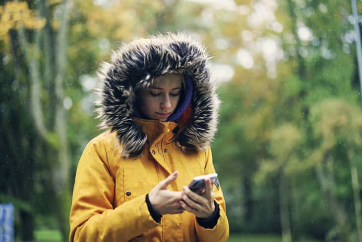 woman in parka in public park on a rainy Autumn day