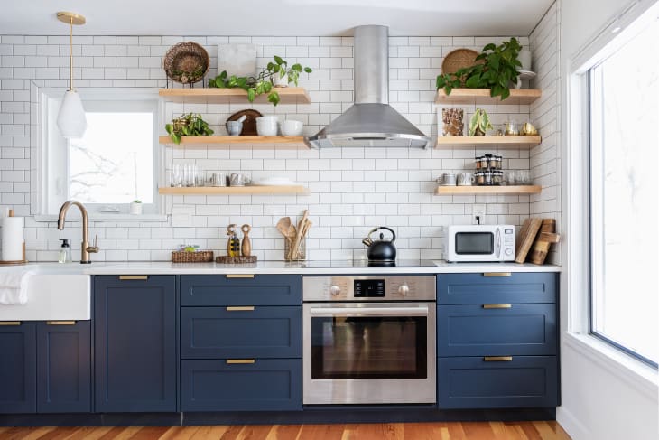 kitchen with open shelving, white tile wall, and blue cabinets/drawers