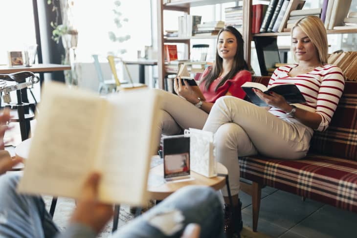Friends reading books and studying for exam together